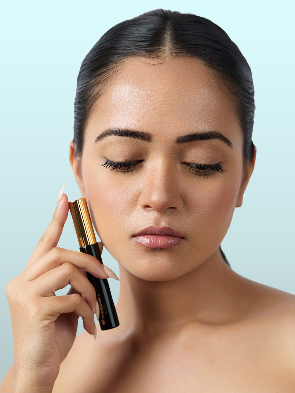 Model holding Wink It mascara with soft everyday eye makeup look
